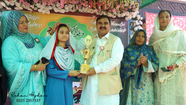 DEO Central Syed Nawaz Ali Shah Jillani presenting a trophy to Ayesha for securing 87% marks in Karachi Board SSC Part-II examinations across New Karachi Town.